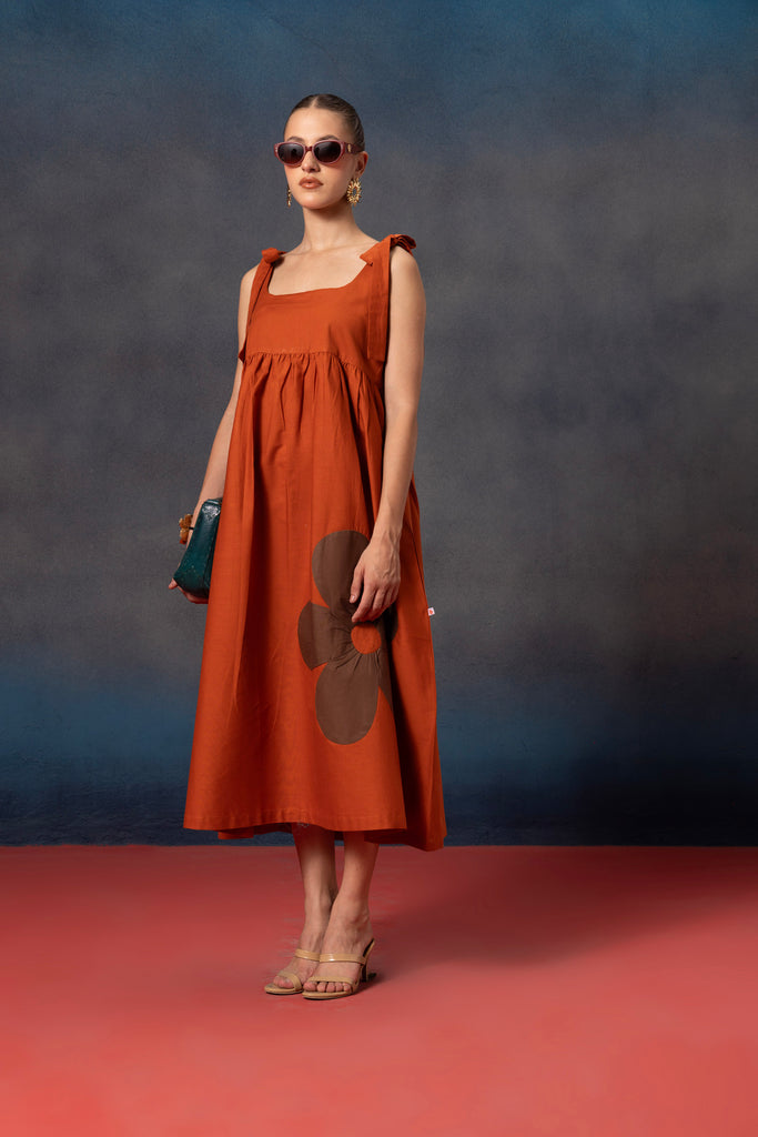 Sleeveless Rust orange midi dress for   women with brown floral patch on it 