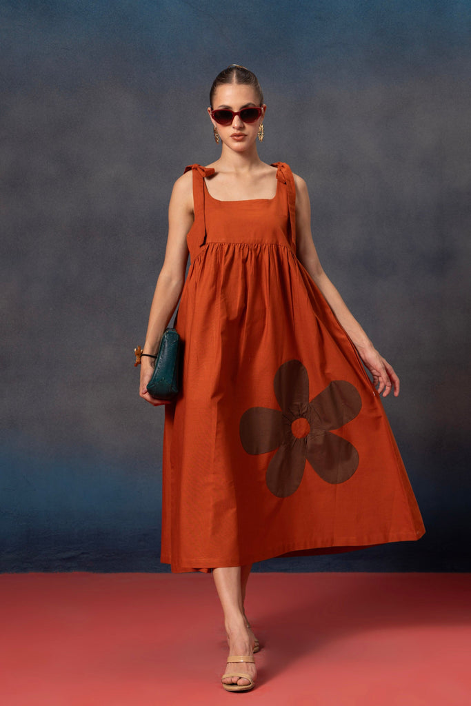 Rust orange midi dress with brown floral patch on it 
